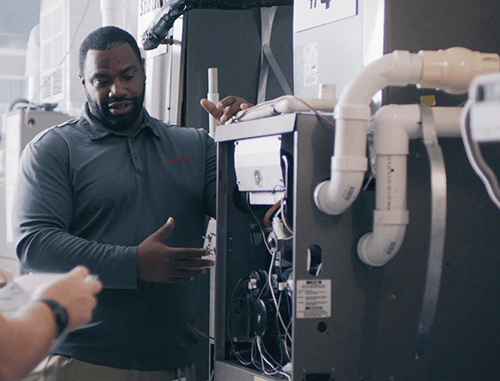 repair technician showing the inside of HVAC equipment