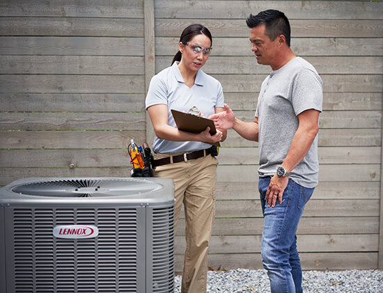 technician giving homeowner HVAC tips in Guelph, ON with a newly installed Lennox air conditioning unit in the foreground