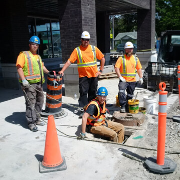 Hy-Mark employees onsite at a backwater valve representing health & safety training